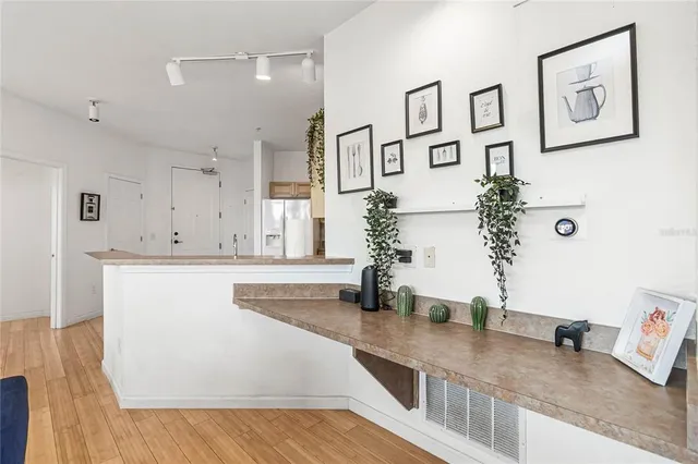 a view of a kitchen with stainless steel appliances granite countertop a sink and a wooden floor