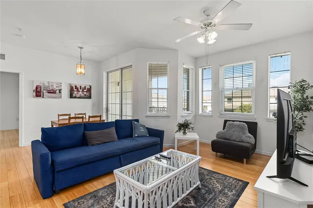 a living room with furniture ceiling fan and a window