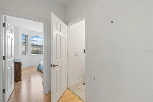 a view of a hallway with wooden floor and closet area