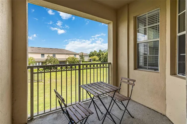 a view of a balcony with furniture and floor to ceiling window