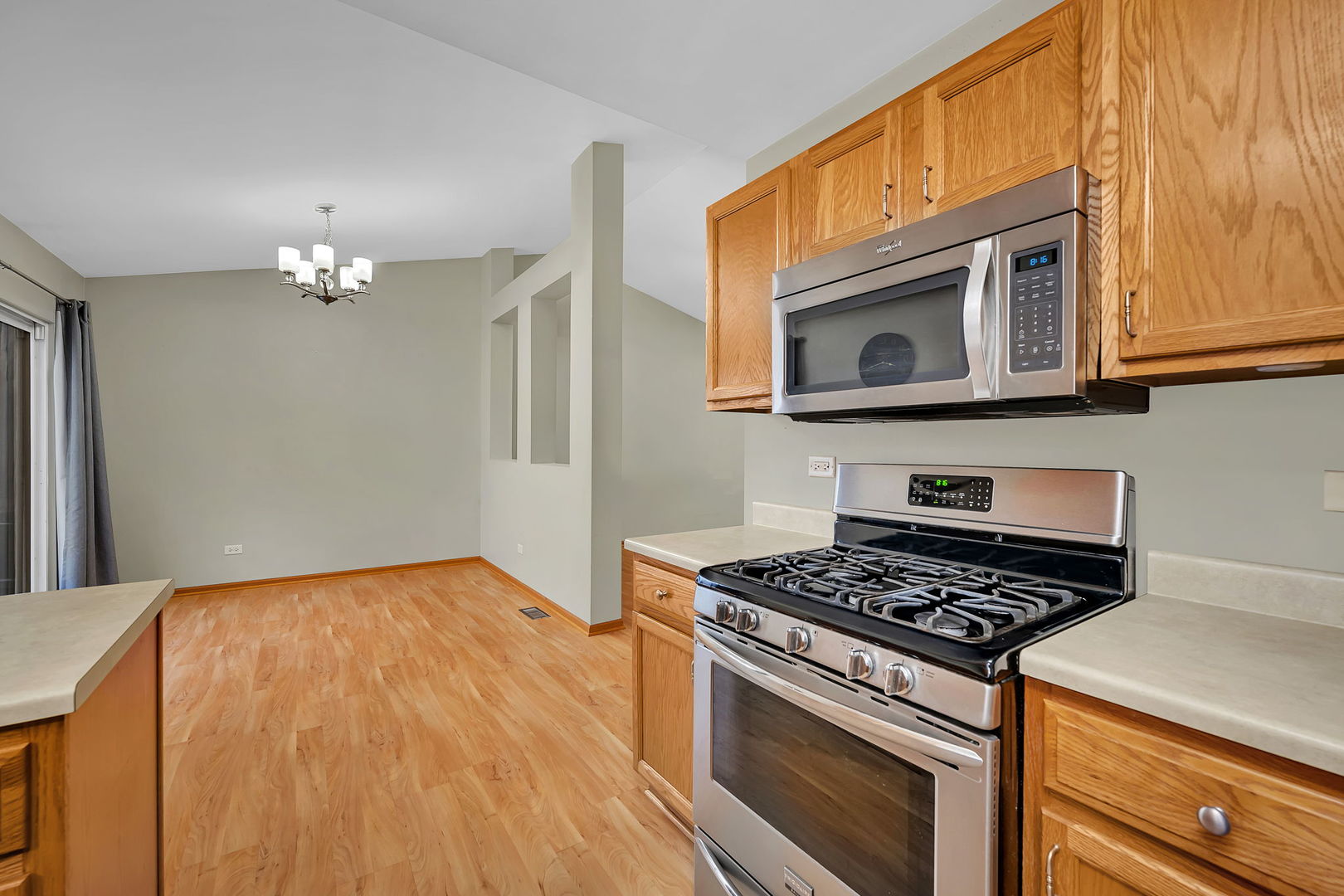 1640 Clover Court Romeoville, IL 60446 - Photo 13 of 30 a kitchen with stainless steel appliances granite countertop a stove and a microwave