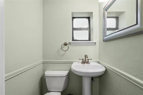 a bathroom with a sink a toilet and a mirror
