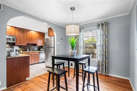 a kitchen with stainless steel appliances a dining table chairs and couches