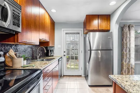 a kitchen with stainless steel appliances granite countertop a refrigerator a stove and a sink