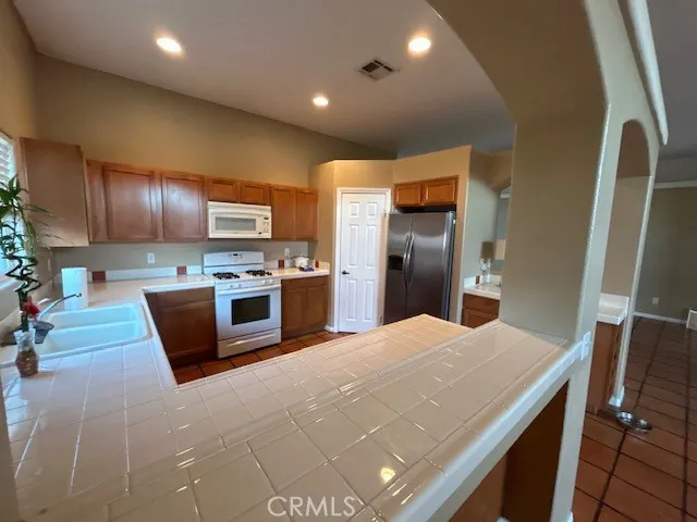 a kitchen with stainless steel appliances granite countertop a refrigerator and a stove top oven