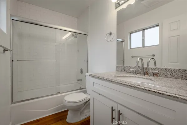 a bathroom with a granite countertop sink toilet and shower