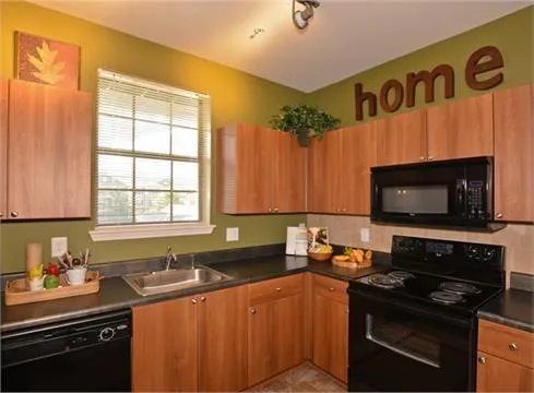 a kitchen with granite countertop a stove sink and cabinets