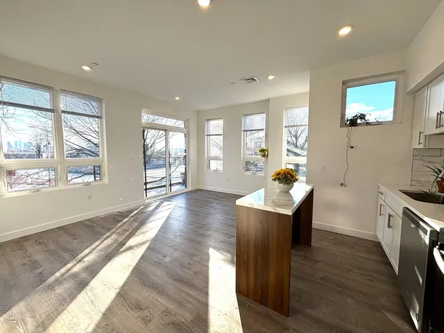 a living room with furniture a wooden floor and a large window