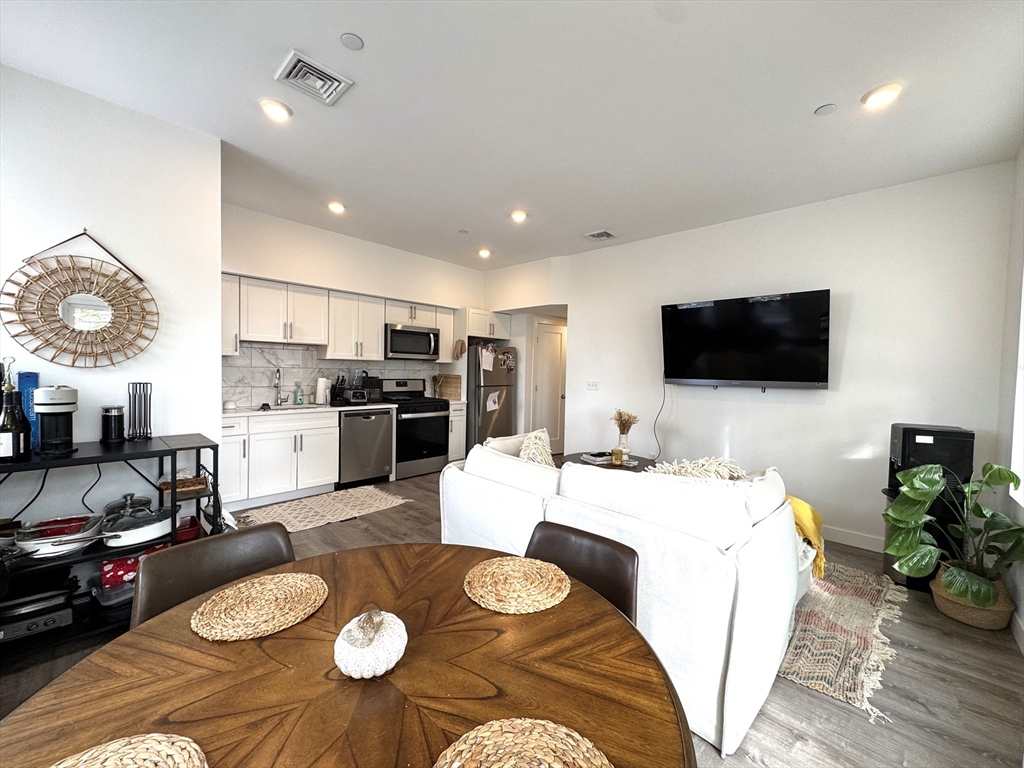 302 Broadway, Unit 303 Everett, MA 02149 - Photo 2 of 11 a living room with furniture and a flat screen tv