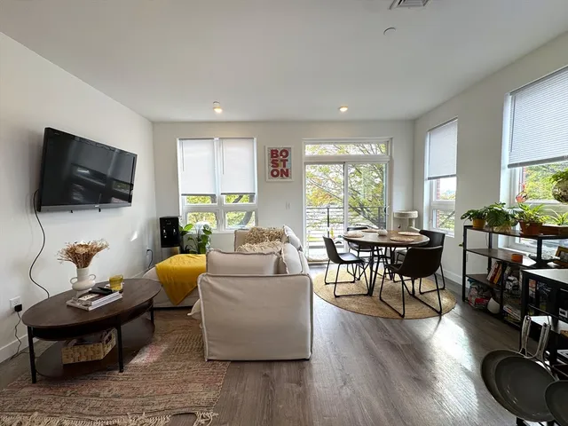 a living room with furniture a flat screen tv and a window
