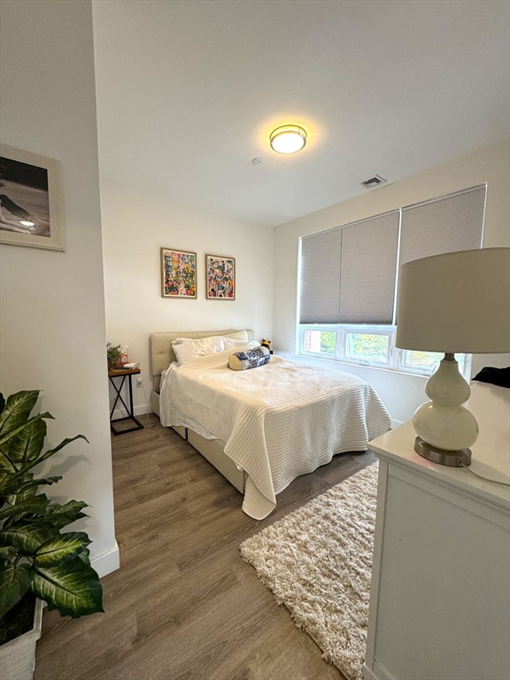 302 Broadway, Unit 303 Everett, MA 02149 - Photo 5 of 11 a bedroom with a bed and a couch