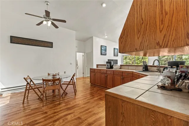 a kitchen with stainless steel appliances kitchen island granite countertop a table chairs in it and wooden floors