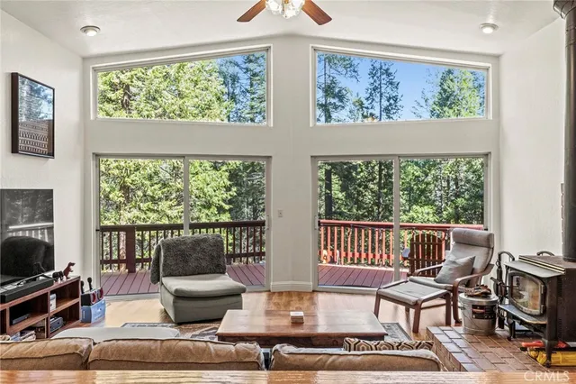 a living room with furniture a flat screen tv and a floor to ceiling window