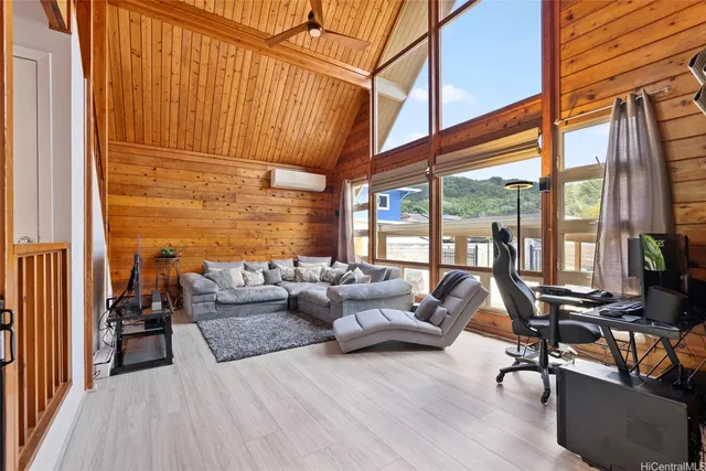 a living room with furniture a floor to ceiling window and wooden floor