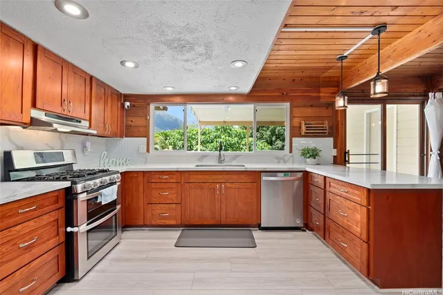 a kitchen with stainless steel appliances granite countertop a stove a sink and a microwave