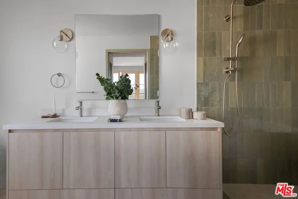 a bathroom with a granite countertop sink a mirror and shower