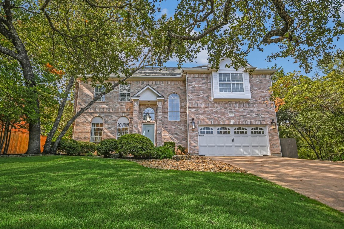Traditional home with concrete driveway, brick siding, and a garage