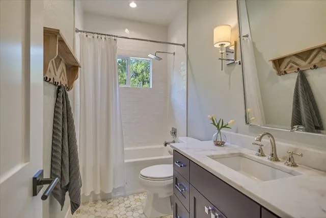 a bathroom with a granite countertop sink toilet and shower