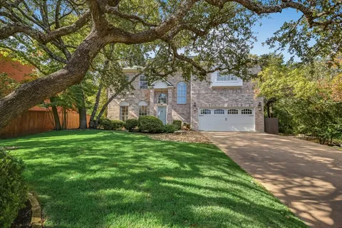 a front view of house with yard and trees