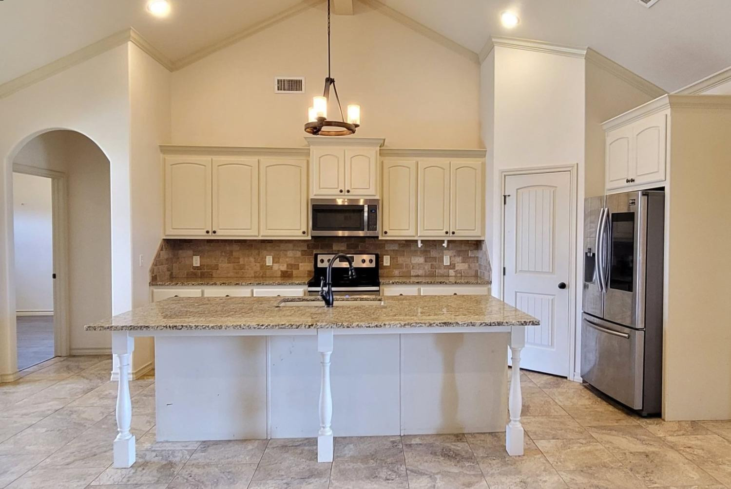5234 Kemper Street Lubbock, TX 79416 - Photo 8 of 28 a kitchen with stainless steel appliances granite countertop a sink a refrigerator and a stove