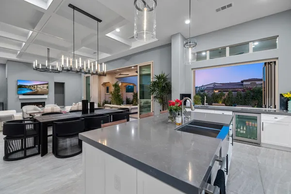 a kitchen with stainless steel appliances kitchen island granite countertop a dining table chairs and view of living room