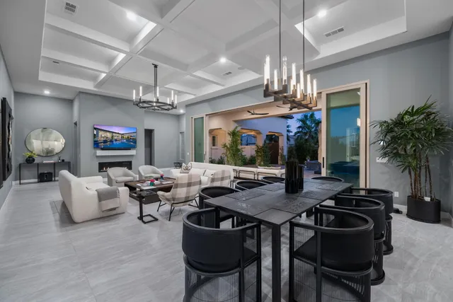 a living room with furniture a chandelier and a flat screen tv