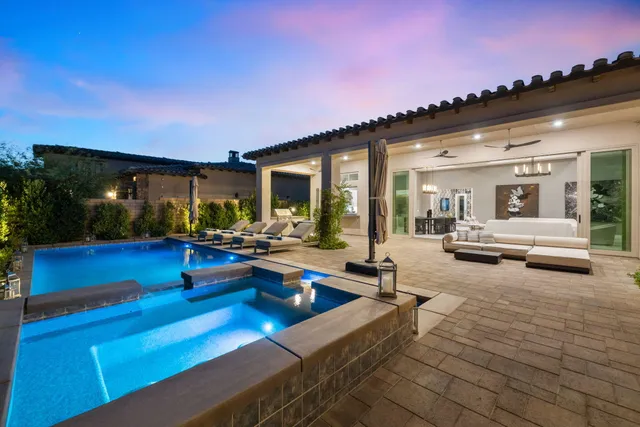 a living room with patio furniture and a chandelier