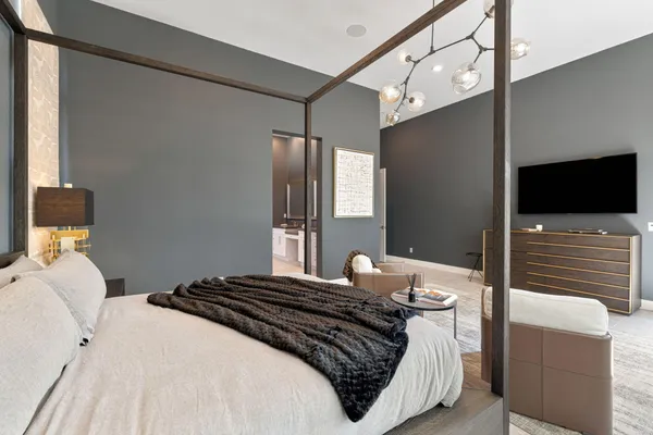 a bedroom with a large bed and a chandelier