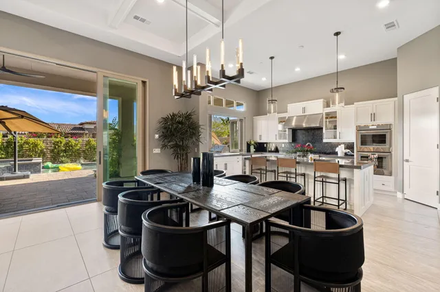 a kitchen with stainless steel appliances kitchen island granite countertop a table chairs microwave and sink