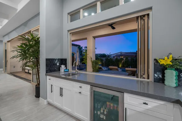 a view of a patio with couches table and chairs with plants and wooden fence