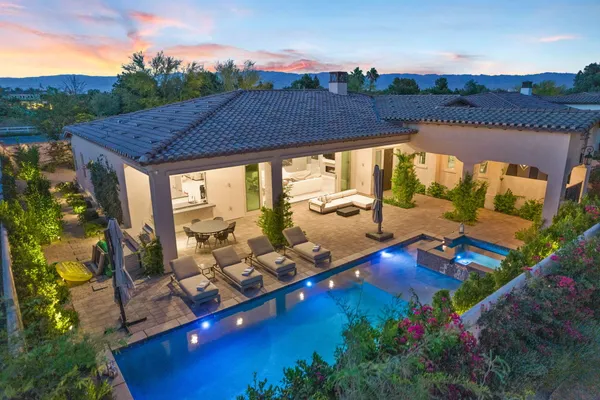 a view of a house with swimming pool and a yard