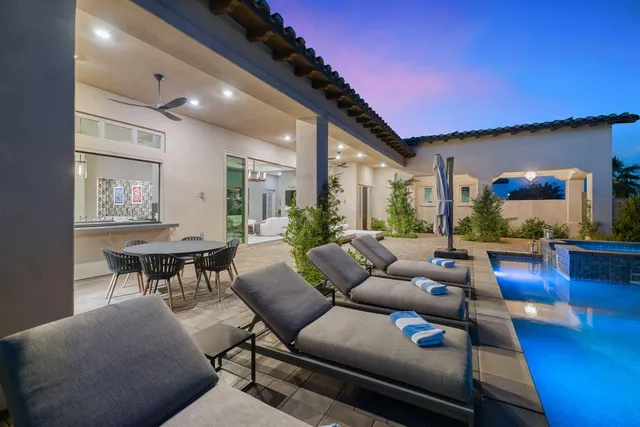 a front view of a house with a yard and palm trees