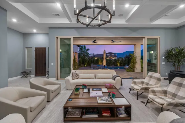 a living room with patio furniture and a chandelier