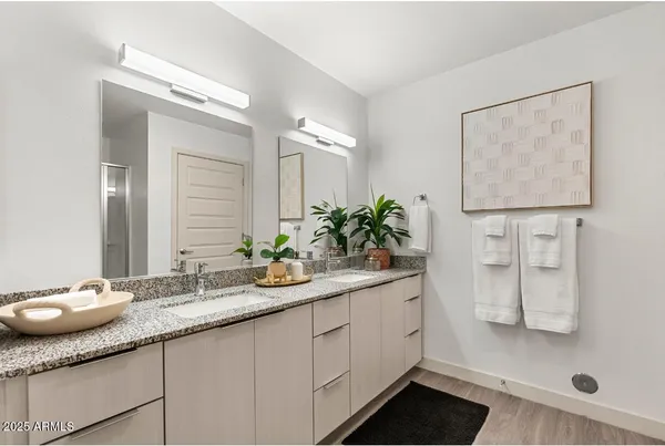 a bathroom with a granite countertop sink a mirror and shower
