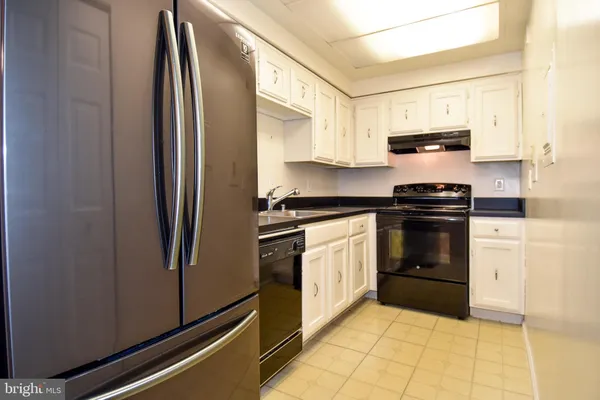 a kitchen with stainless steel appliances granite countertop a refrigerator sink and stove
