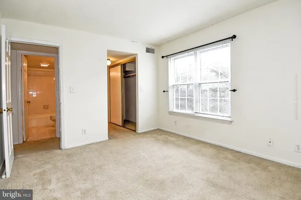 an empty room with windows and closet
