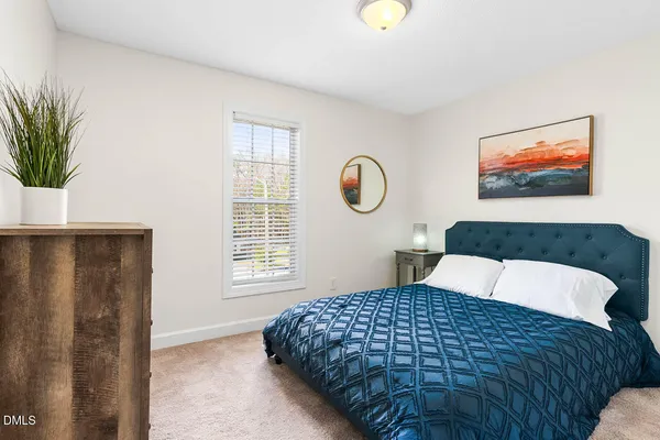 a bedroom with a bed and a potted plant