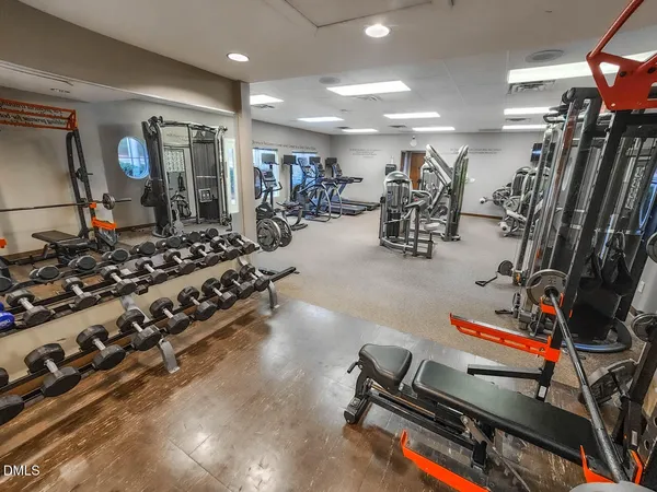 a room with gym equipment and large mirror