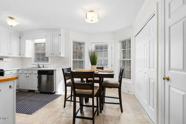 a kitchen with a table chairs sink and cabinets