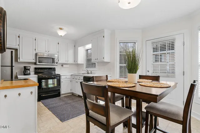 a kitchen with granite countertop white cabinets and stainless steel appliances