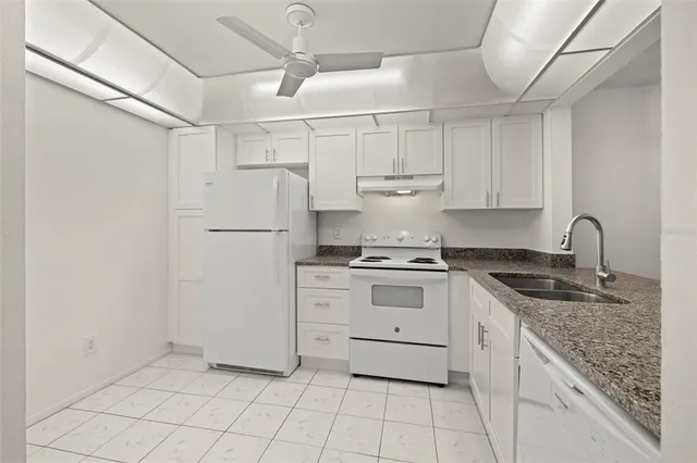 a kitchen with white cabinets appliances and sink