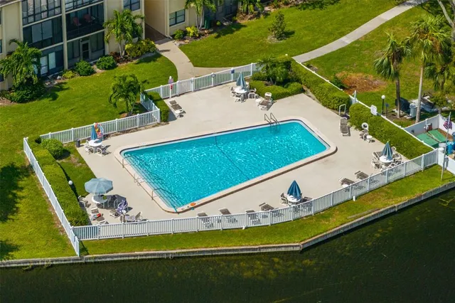 an aerial view of a city with lots of residential buildings ocean and mountain view in back