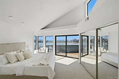 a bedroom with a bed and a large window with outer view