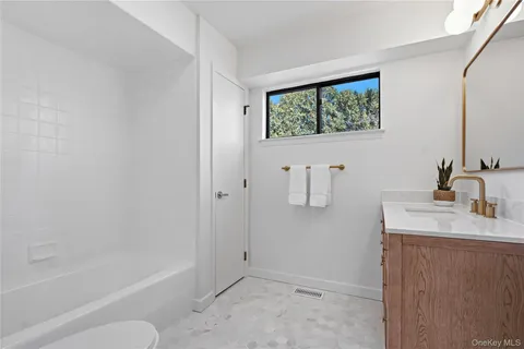 a bathroom with a tub sink and mirror