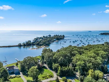 an aerial view of ocean and residential houses with outdoor space