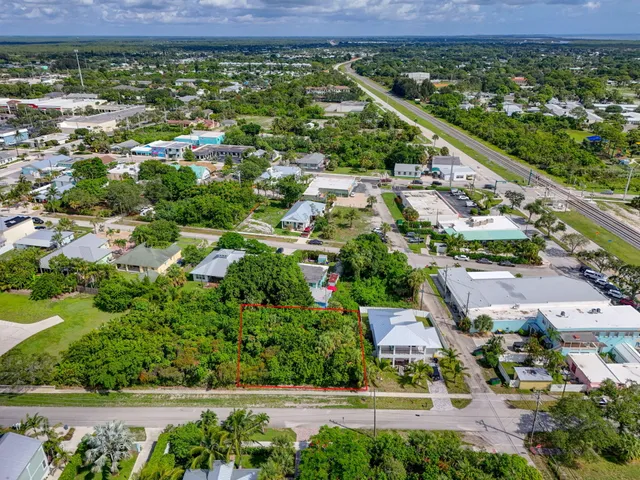 an aerial view of a city with lots of residential buildings ocean and mountain view