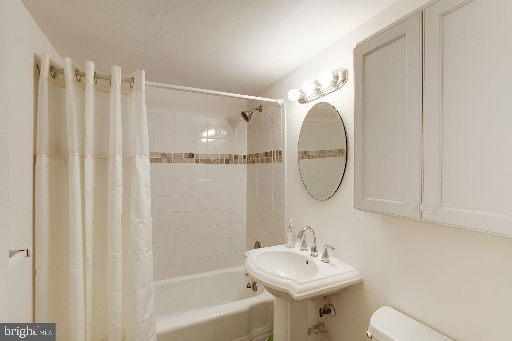522 21st Street Northwest, Unit 301 Washington, DC 20006 - Photo 11 of 29 a bathroom with a sink a mirror and a shower
