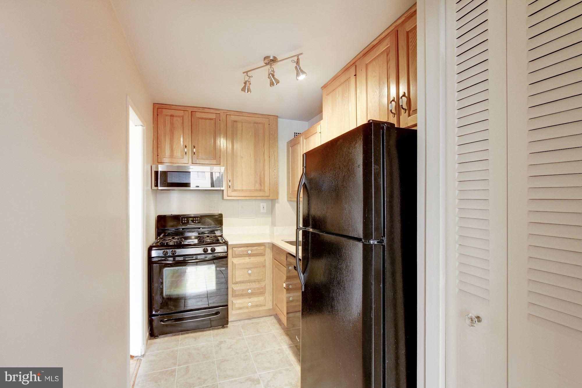 522 21st Street Northwest, Unit 301 Washington, DC 20006 - Photo 4 of 29 a kitchen with a refrigerator and a stove top oven