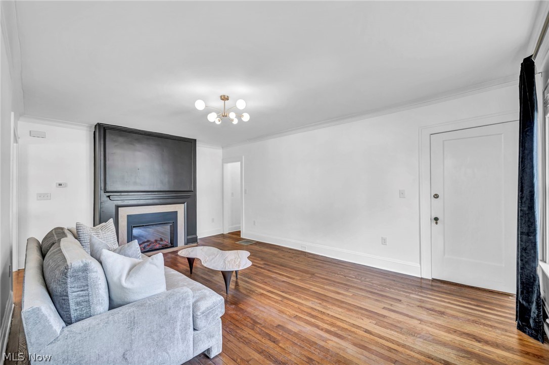 2135 Coventry Road, Unit DOWN Cleveland, OH 44118 - Photo 5 of 34 Living area with hardwood / wood-style flooring, crown molding, suspended lighting, and a large fireplace