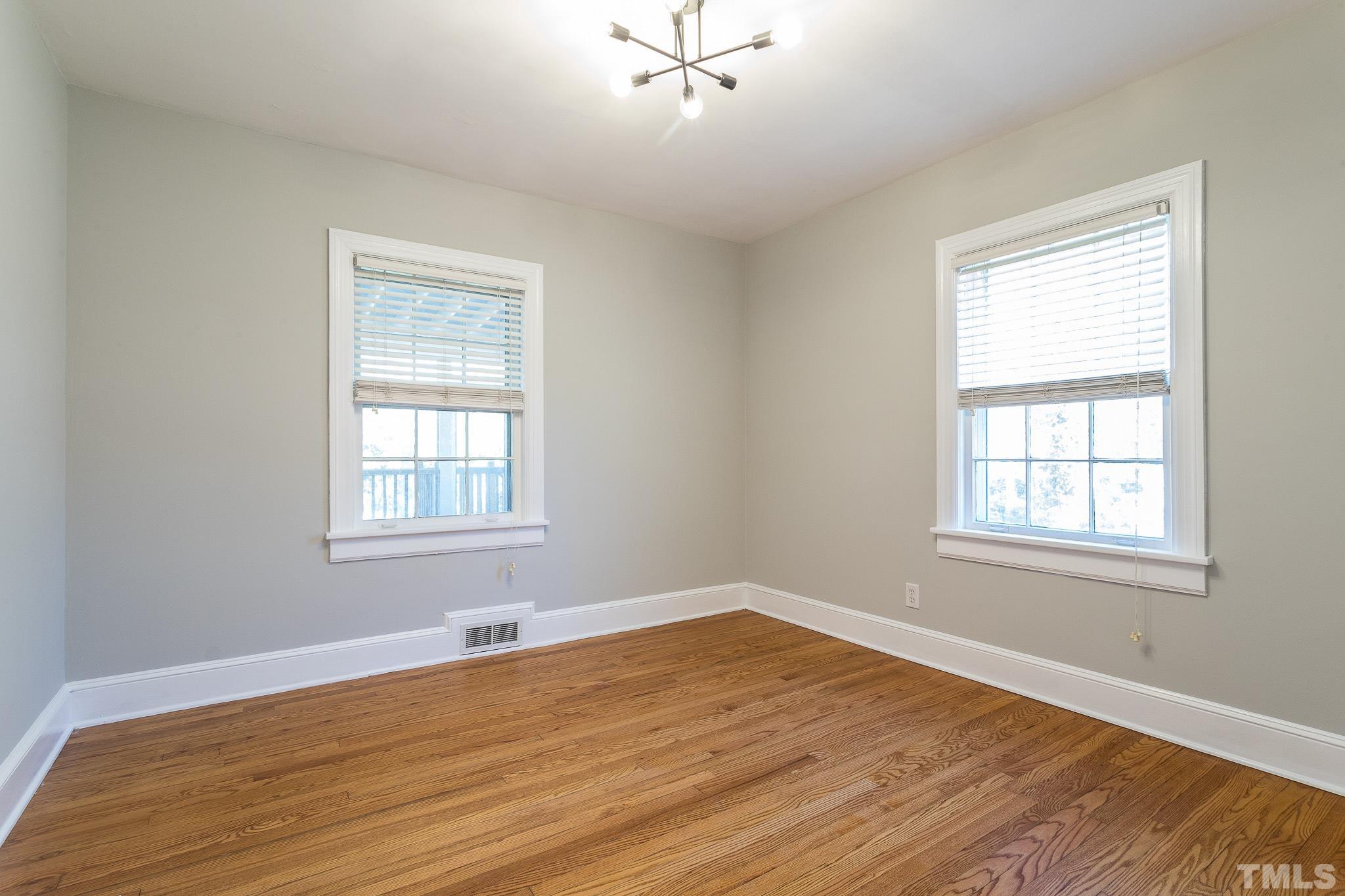 2725 Anderson Drive Raleigh, NC 27608 - Photo 13 of 27 a view of an empty room with wooden floor and a window